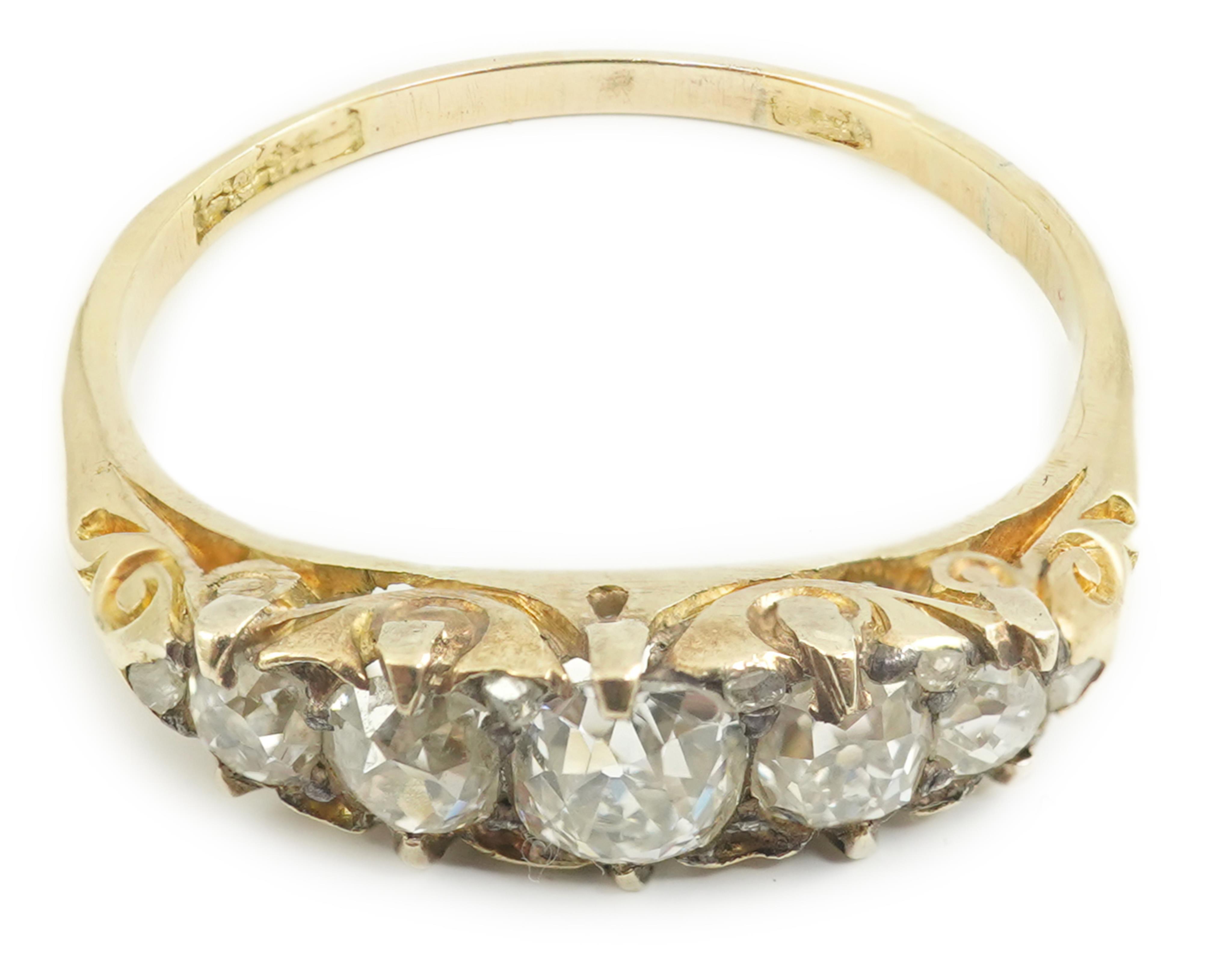 An early 20th century gold and graduated five stone old cut diamond set half hoop ring